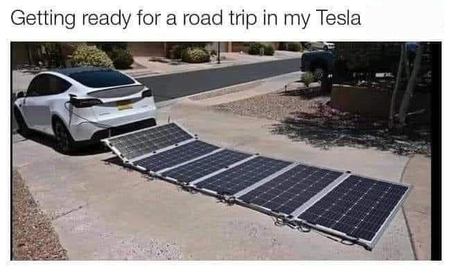 An electric car towing a long row of solar panels.